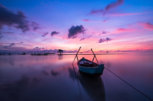 łódka na jeziorze podczas zachodu słońca