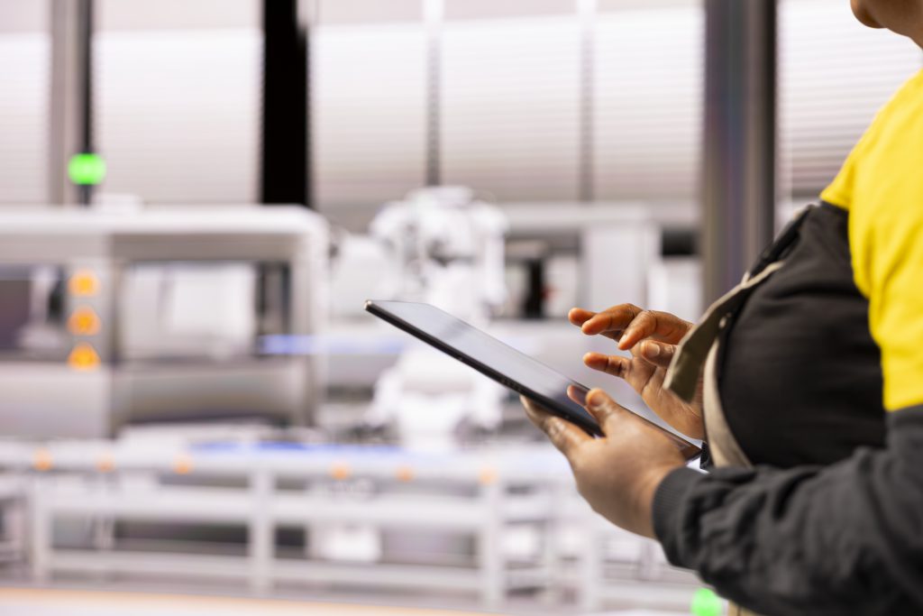 Operator korzysta z tabletu do obsługi systemu kontroli produkcji w Krakowie