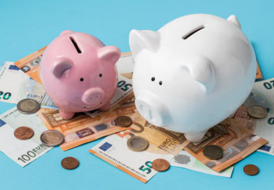 dwie świnki skarbonki położone na banknotach pieniędzy obrazujące program oszczędnościowy