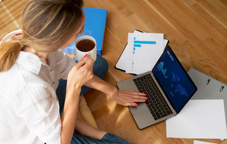 Kobieta siedząca przy laptopie czytająca bloga finansowego.