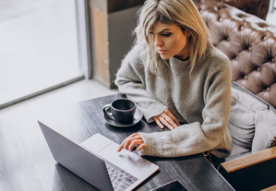 kobieta siedząca przy biurku czytająca blog finansowy