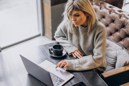 kobieta siedząca przy biurku czytająca blog finansowy