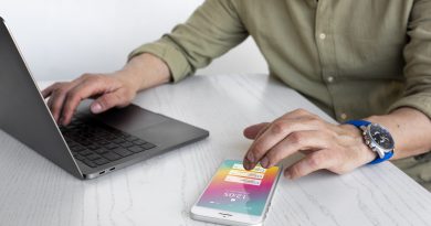 Osoba pracująca nad tworzeniem aplikacji webowych na laptopie i smartfonie.