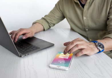 Osoba pracująca nad tworzeniem aplikacji webowych na laptopie i smartfonie.