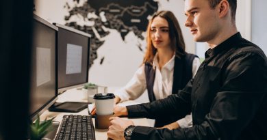 Specjaliści IT pracują nad projektem outsourcingu IT przy stanowisku komputerowym w biurze.