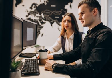 Specjaliści IT pracują nad projektem outsourcingu IT przy stanowisku komputerowym w biurze.