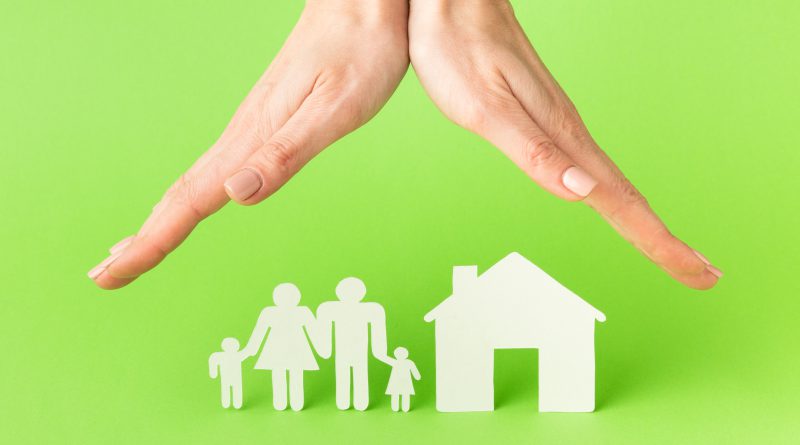 Dłonie wskazujące na postać domu i rodziny - ubezpieczenia majątkowe