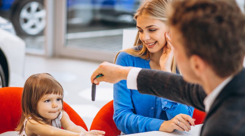 Mama z córką odbierają kluczyki do auta w salonie – rozmowa o ubezpieczeniach majątku przy zakupie samochodu