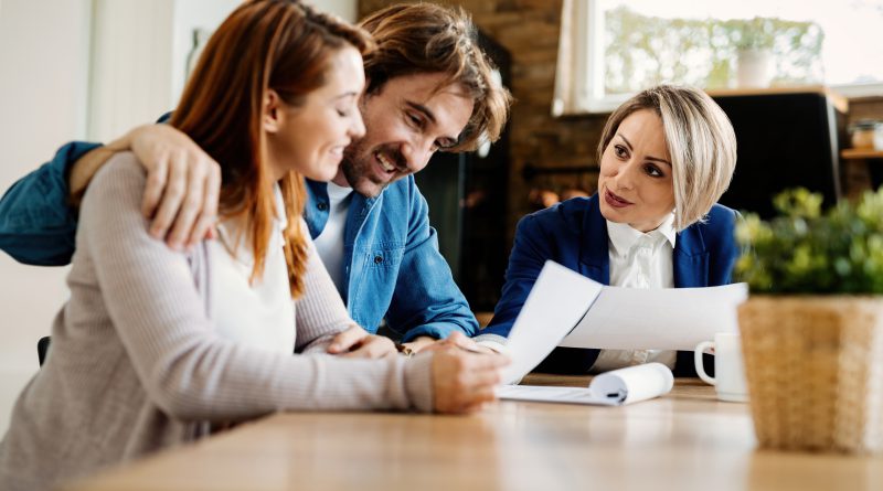 Młoda para omawia z doradcą dokumenty dotyczące finansów i ubezpieczenia majątku w domu